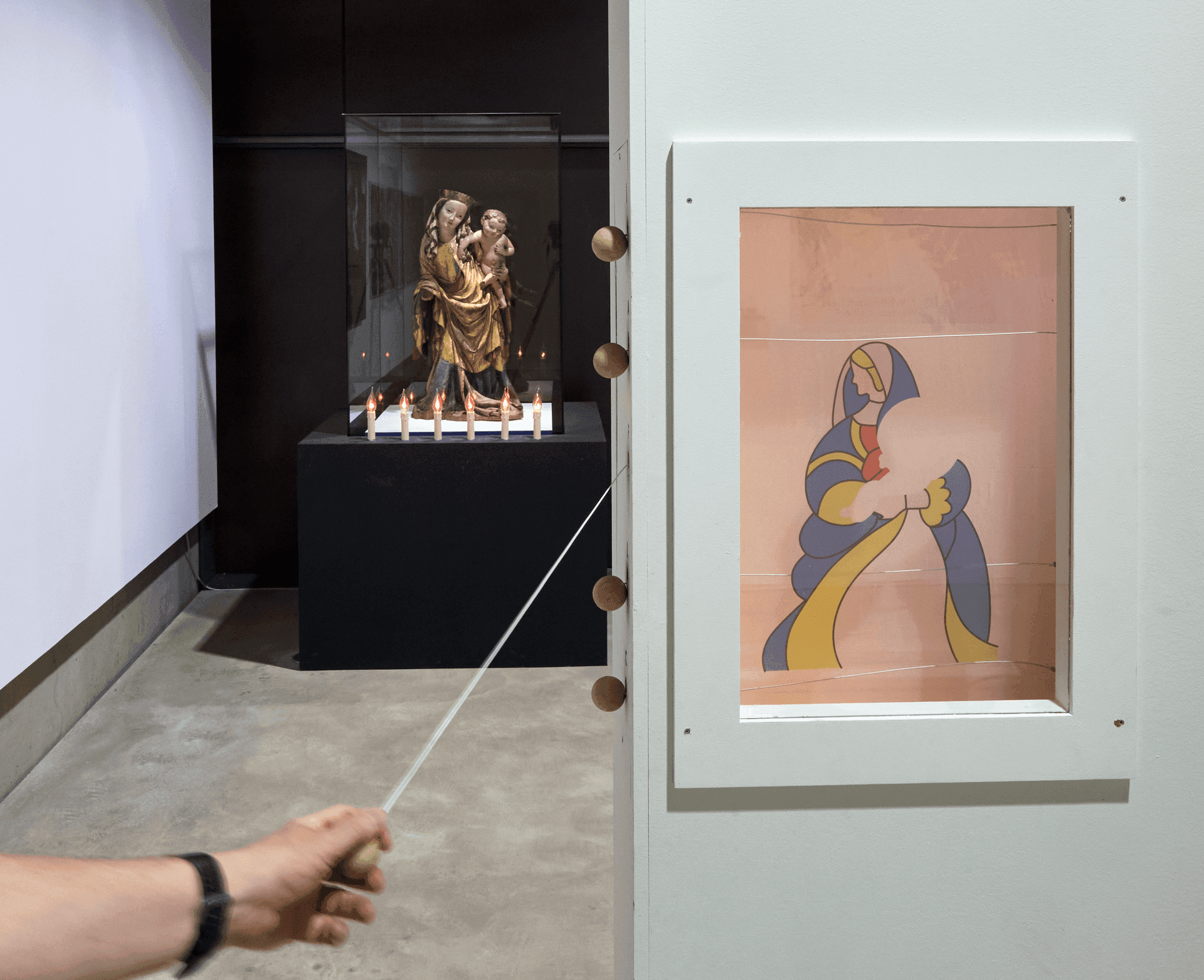 Besucher zeigt mit einem Stab auf eine Heiligenfigur in der Vitrine – Foto: Jürgen Vogel LVR-Landesmuseum Bonn